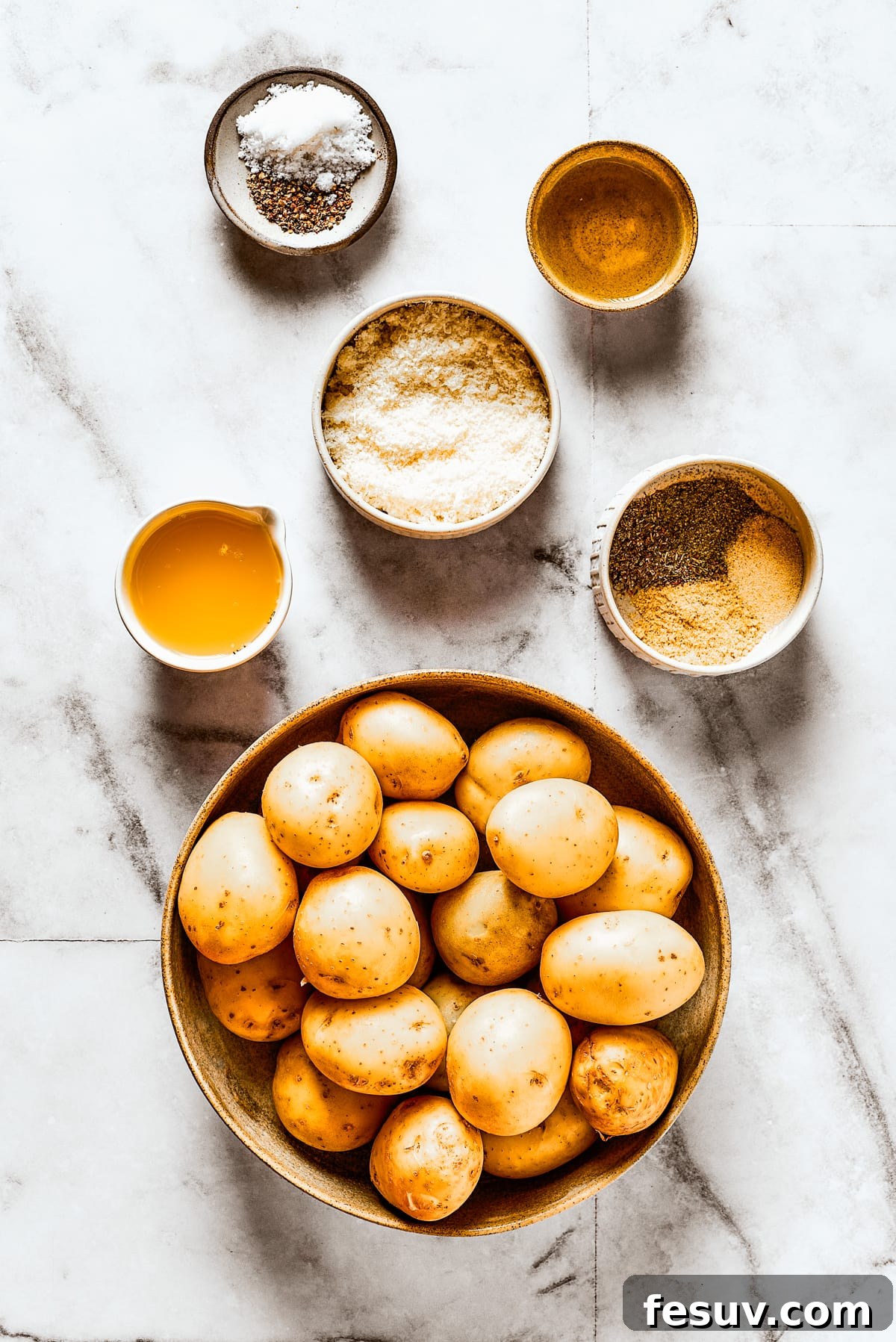 These tender potatoes with a crunchy, cheesy crust are the easiest, tastiest side dish you'll ever make. A viral TikTok recipe you'll love! Ingredients for roasted parmesan crusted potatoes, arranged on a work surface.
