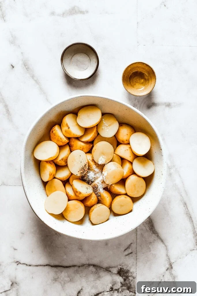 These tender potatoes with a crunchy, cheesy crust are the easiest, tastiest side dish you'll ever make. A viral TikTok recipe you'll love! Cut potatoes in a bowl with salt, pepper, and oil.