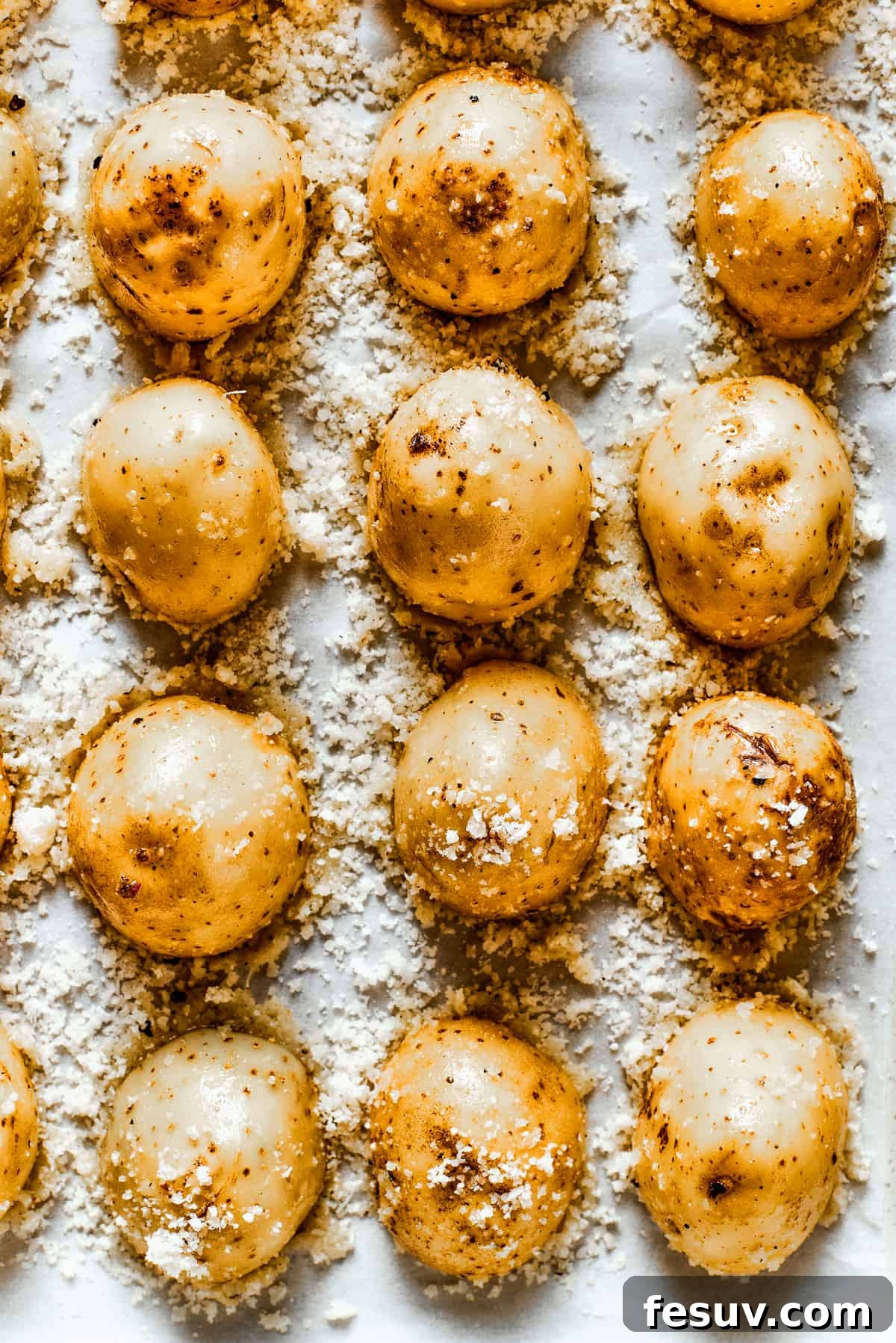These tender potatoes with a crunchy, cheesy crust are the easiest, tastiest side dish you'll ever make. Close-up of baked parmesan-crusted potatoes in a baking dish.