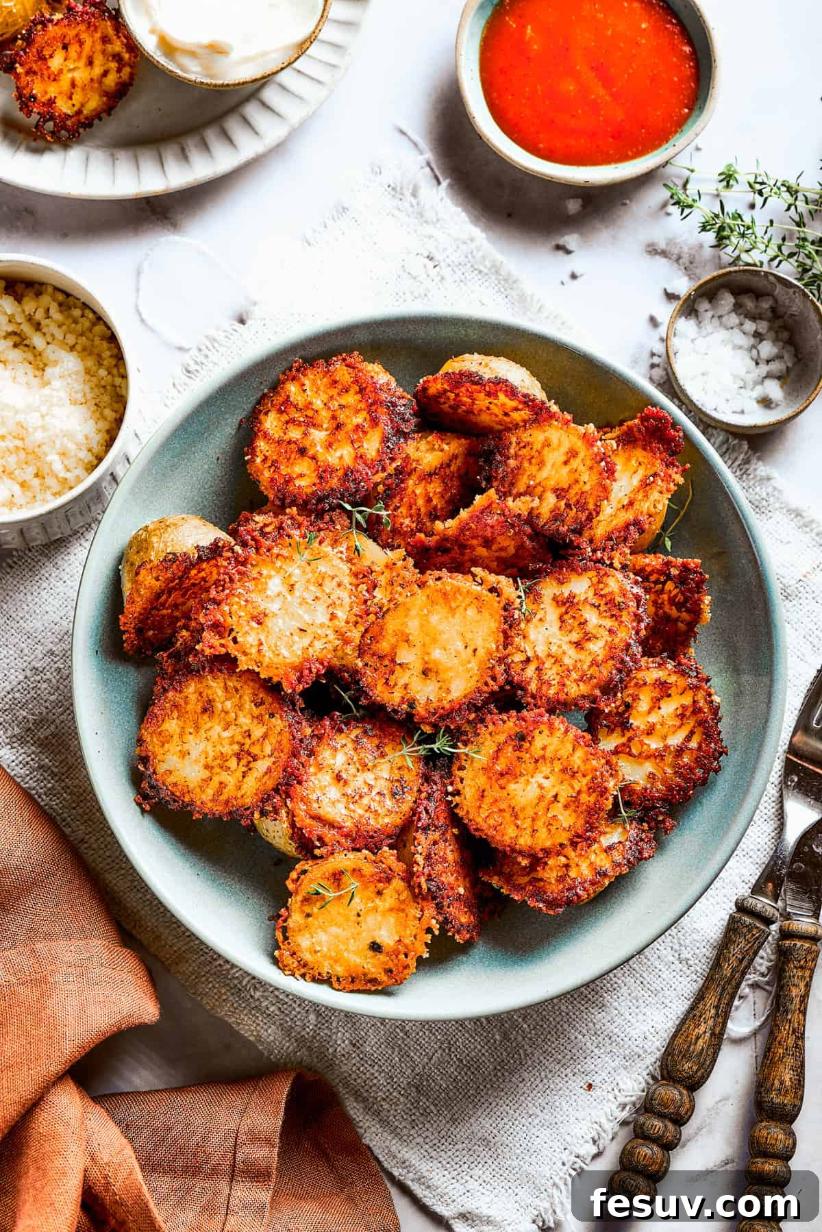 These tender potatoes with a crunchy, cheesy crust are the easiest, tastiest side dish you'll ever make. A viral TikTok recipe you'll love! A bowl of baked potato halves crusted with parmesan cheese.