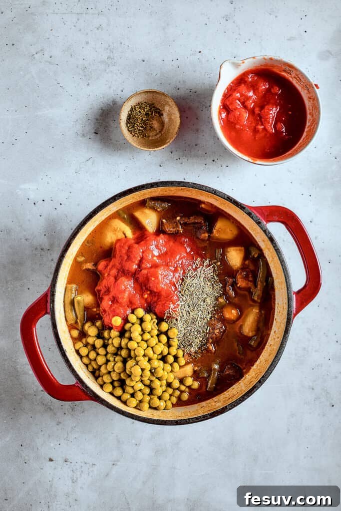 As the air gets crisper and the leaves turn golden, it's time to cozy up with a bowl of pure comfort - this old-fashioned Mulligan Stew! Adding peas to stew.