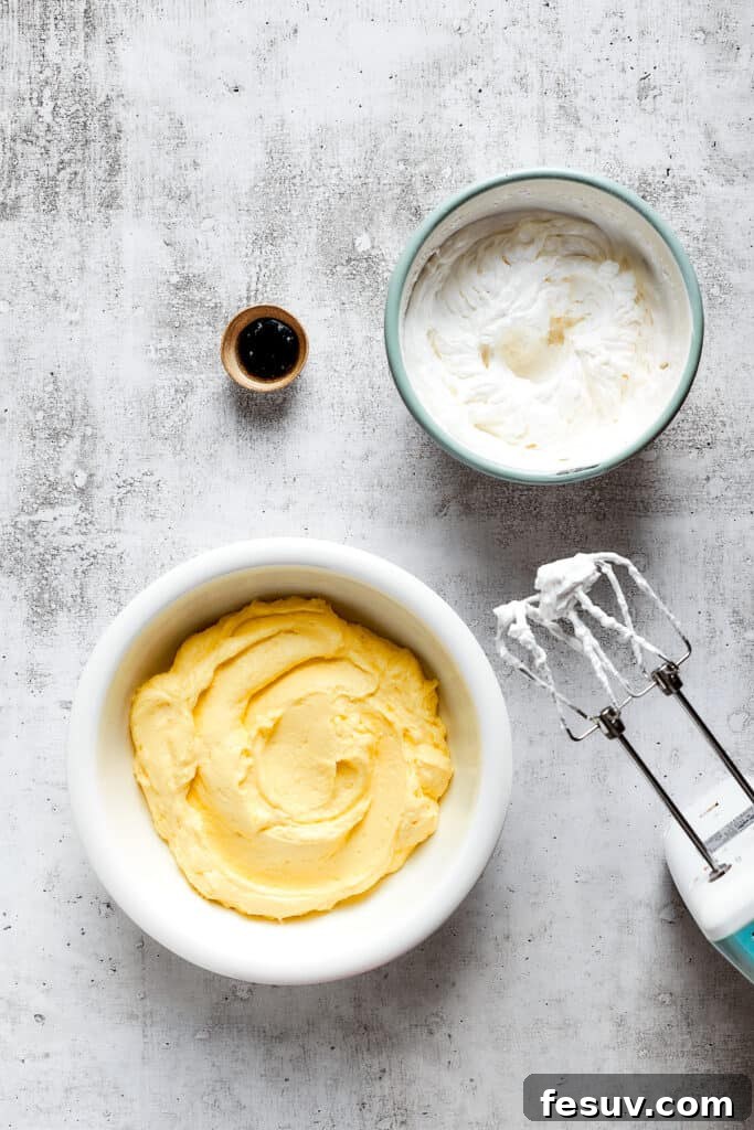 A bowl of vanilla pudding next to a bowl of whipped cream and a bowl of vanilla extract, with a beater.