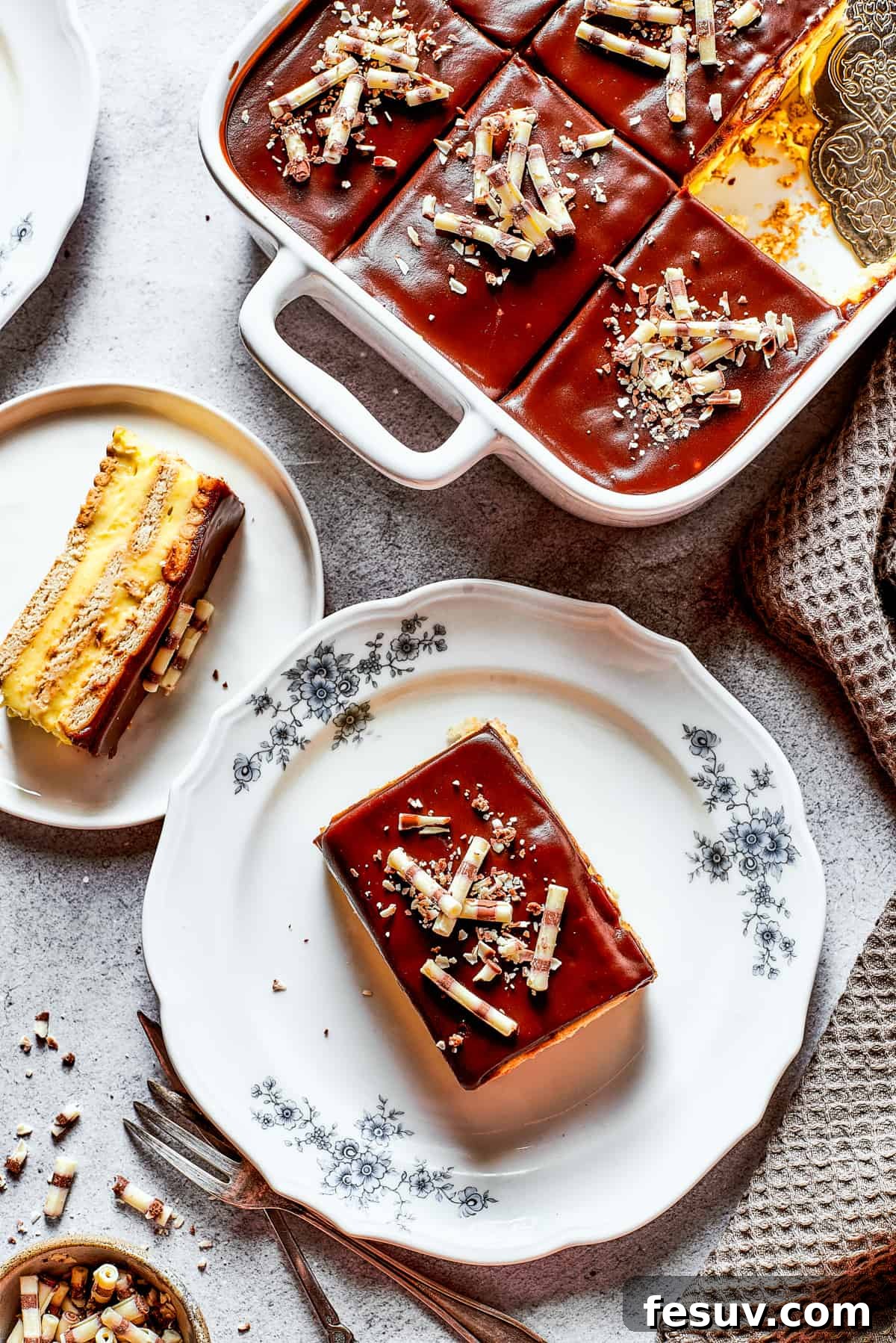 Overhead shot of chocolate eclair cake in a baking dish, and a couple of slices of the cake served on dessert plates.