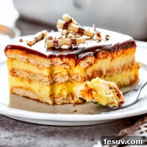 A slice of chocolate eclair cake on a plate, with a fork on the plate with a bite of cake.
