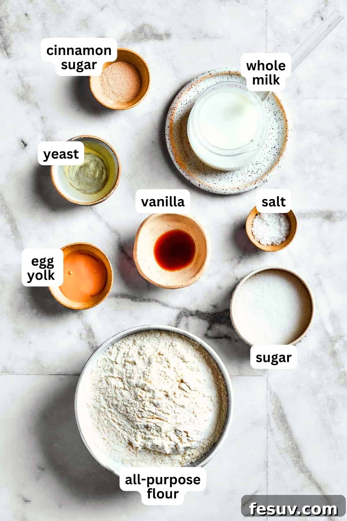 An inviting overhead shot displaying all the essential ingredients laid out for making Star Bread: warm milk, sugar, yeast, flour, salt, vanilla extract, vegetable oil, egg yolk, unsalted butter, brown sugar, and cinnamon. All ready for baking this festive pull-apart bread.