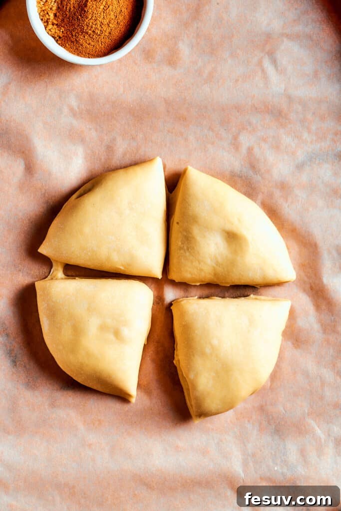 Overhead view of soft Star Bread dough neatly cut into four equal segments, ready for rolling and layering with cinnamon sugar.
