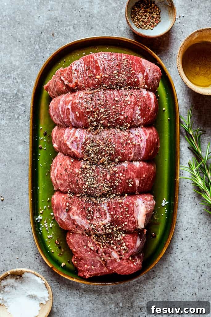 Seasoning and Tying the Top Round Roast Raw beef top round roast generously seasoned with salt and pepper, tied with kitchen twine, ready for searing.