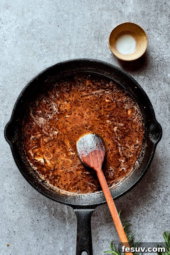 Finished Caramelized Onion Gravy A thick and savory caramelized onion gravy simmering to perfection in a skillet.