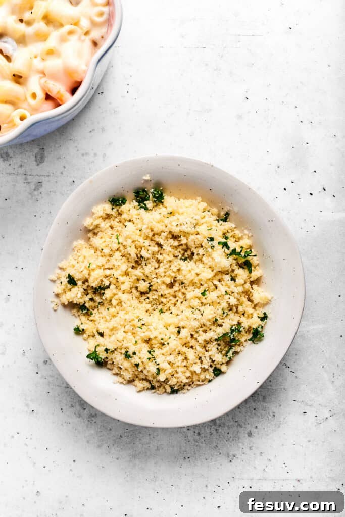 The seasoned parmesan breadcrumbs spread out on a plate, ready to be sprinkled over the casserole.