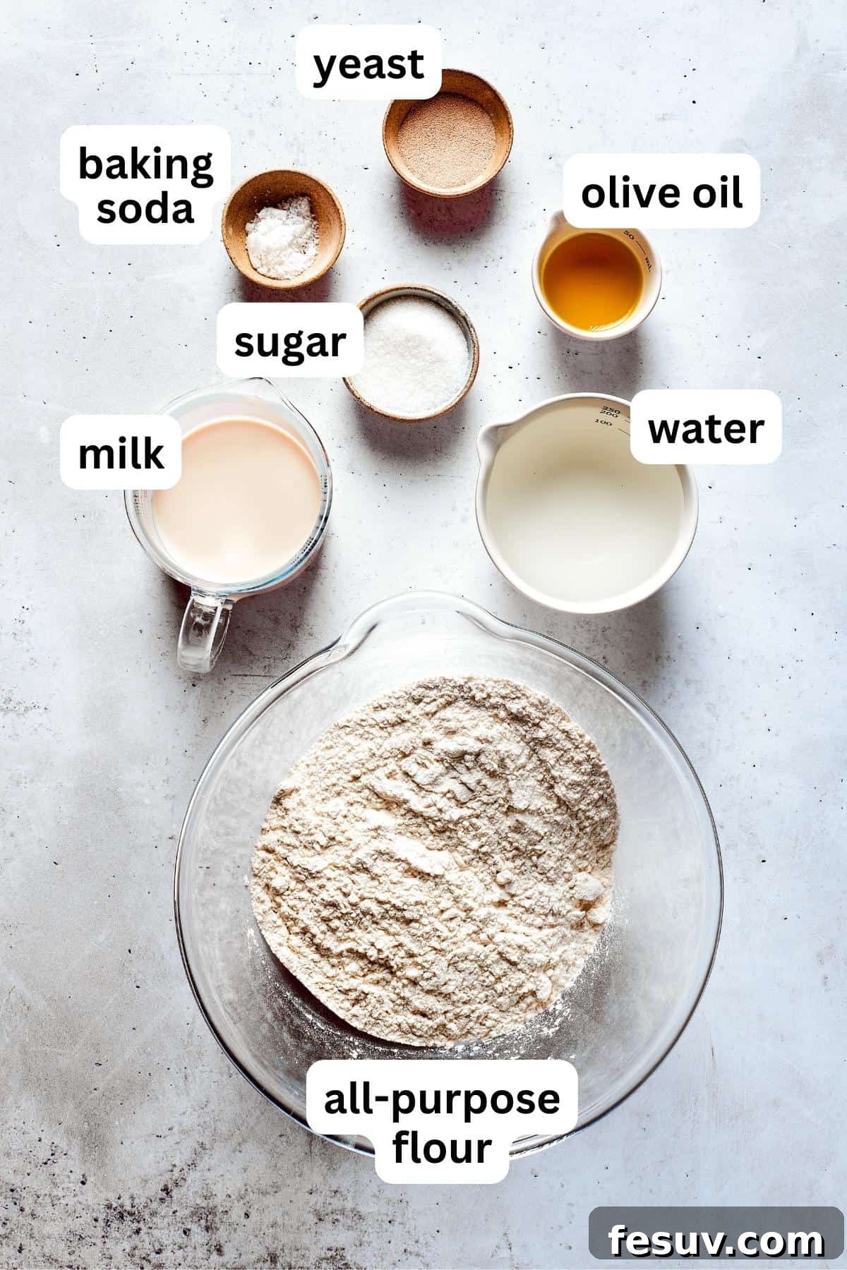 Ingredients for soft pretzels are shown portioned out into bowls: all-purpose flour, active dry yeast, granulated sugar, milk, water, and olive oil.