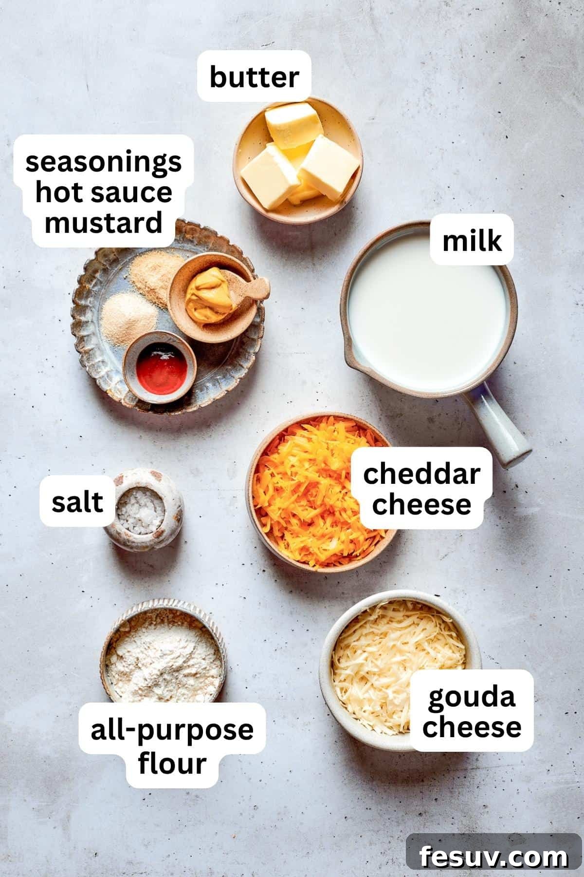 Ingredients to make pretzel dip are shown portioned out: cheese, milk, mustard, onion powder, salt, garlic powder, and cayenne pepper.