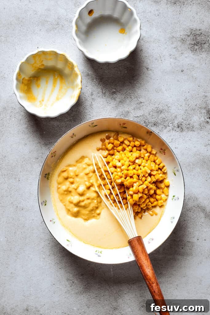 Golden Cloud Corn Souffle 5 Whole kernel corn and creamed corn being added to a mixing bowl with the souffle base.
