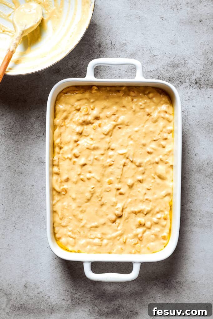 Golden Cloud Corn Souffle 8 The smooth corn souffle batter ready in a white baking pan before baking.