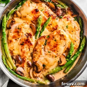 Overhead image of Chicken Madeira in a skillet with asparagus spears and mushrooms.
