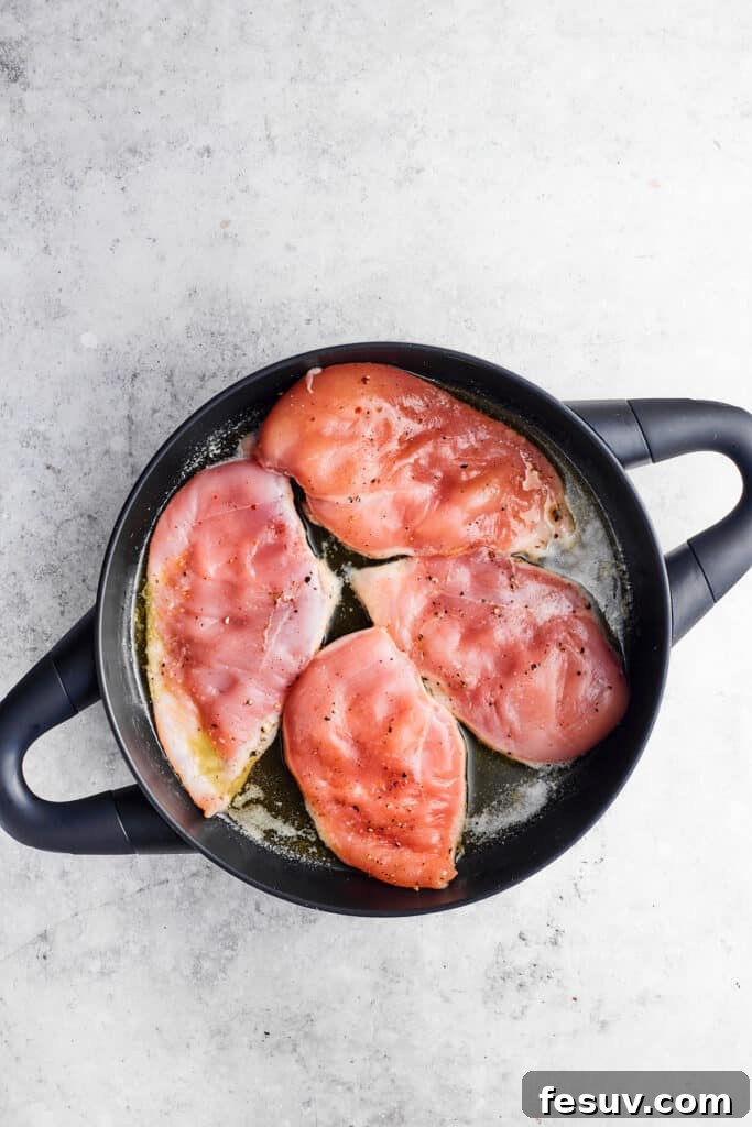 Searing chicken cutlets to golden perfection for Chicken Madeira. Chicken breasts being browned in a hot skillet with olive oil, creating a delicious crust.