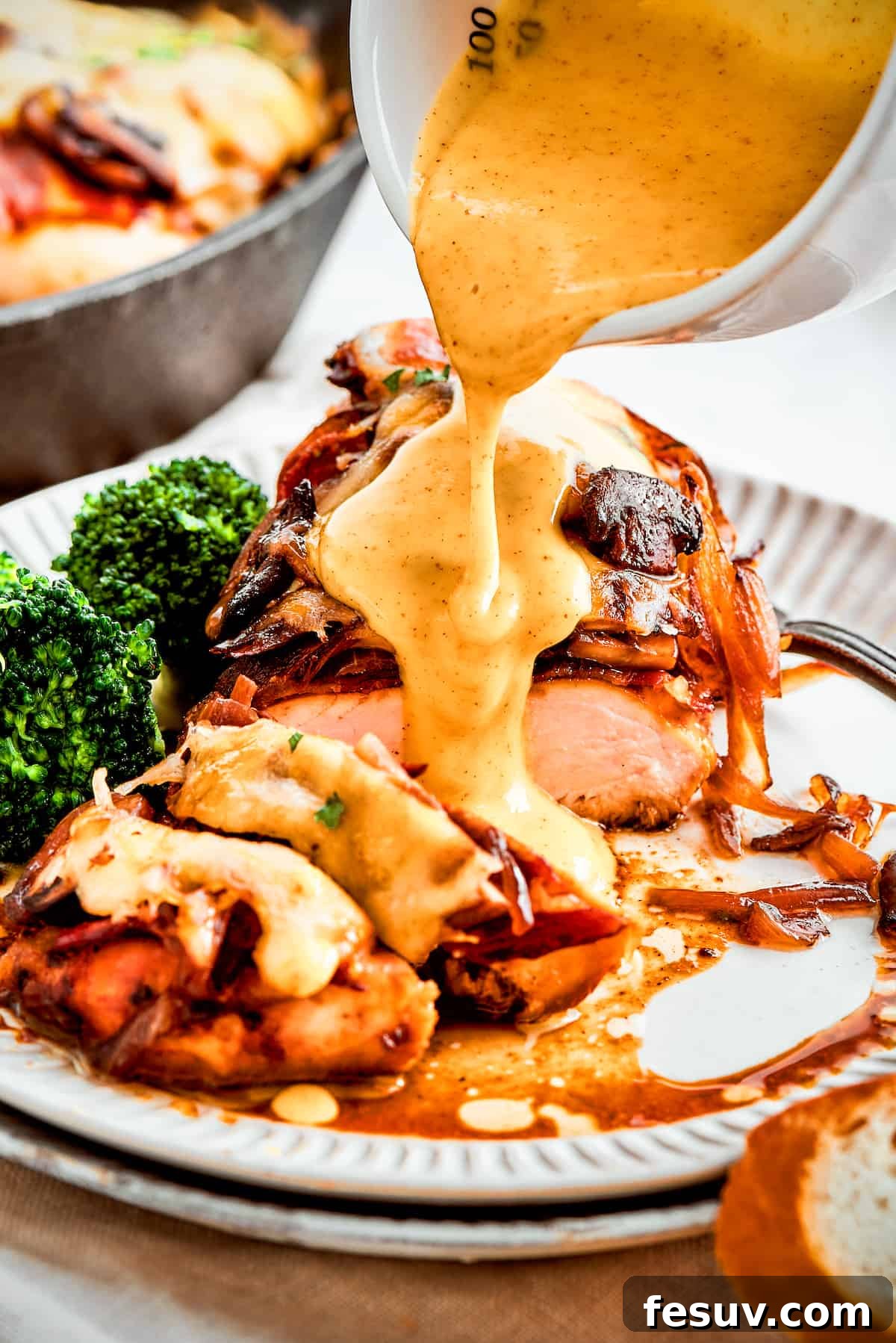A thick stream of vivid yellow honey mustard sauce is added to a plate of Alice Springs chicken.