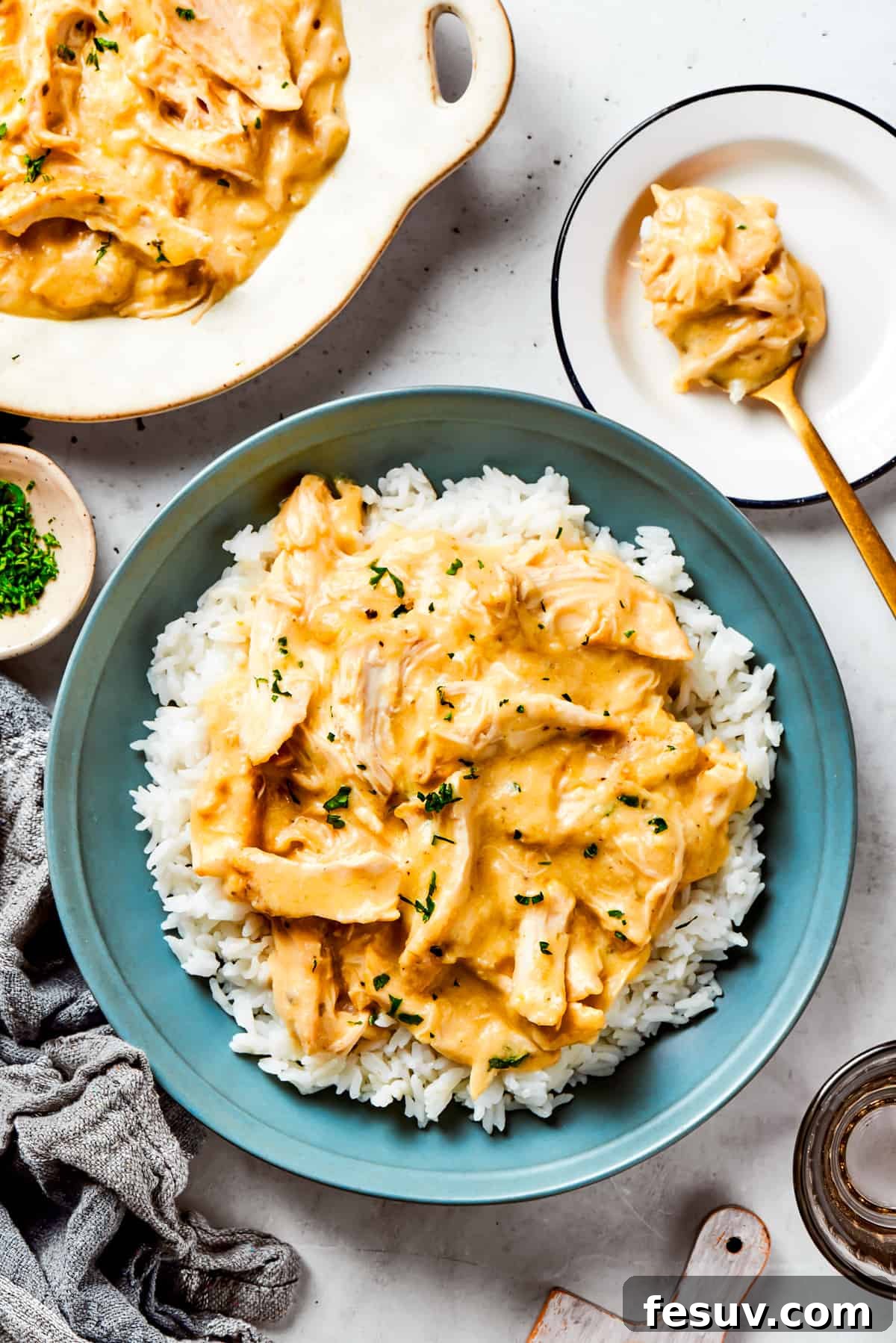 Chicken gravy served over a bed of rice in a blue bowl.