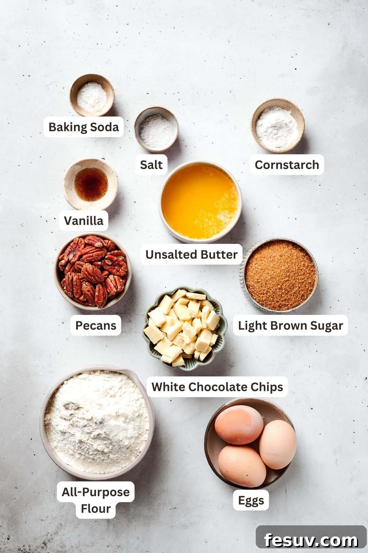 This sweet and irresistible Blonde Brownies recipe features blondies studded with white chocolate chips and crunchy pecans. The organized ingredients for blonde brownies are neatly portioned out on a surface, including flour, cornstarch, baking soda, salt, vanilla extract, brown sugar, melted butter, eggs, chopped pecans, and white chocolate chips.