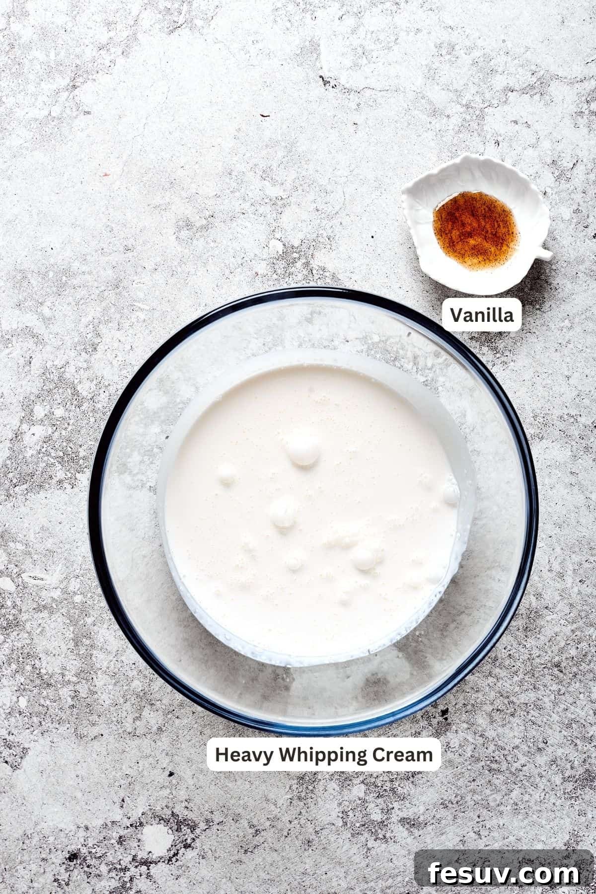 The simple yet crucial ingredients for the whipped cream topping: a carton of heavy cream and a bottle of vanilla extract or bean paste.
