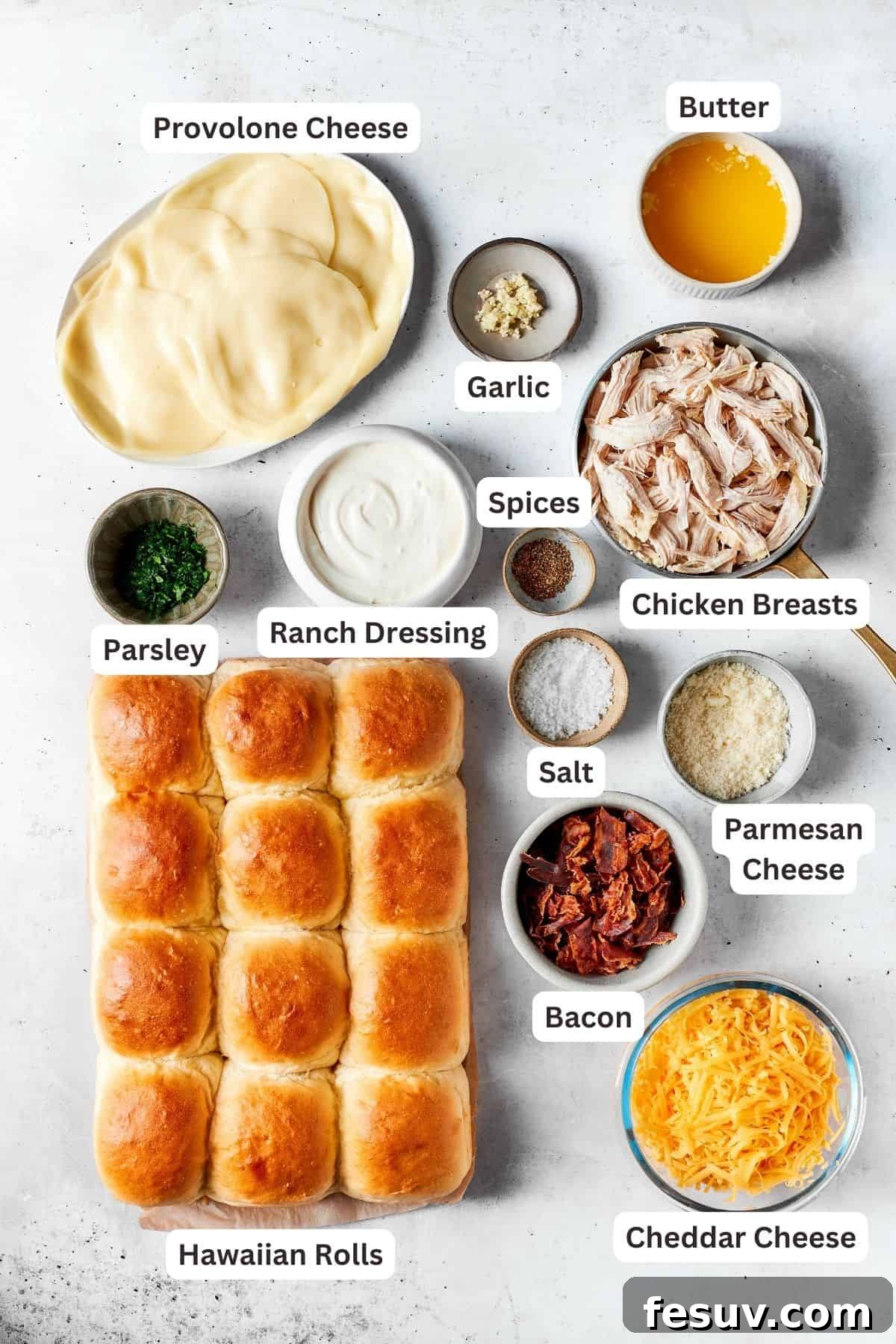 A vibrant spread of fresh, quality ingredients essential for crafting perfect Chicken Bacon Ranch Sliders. All the fresh ingredients for chicken bacon ranch sliders: sweet Hawaiian rolls, slices of provolone, shredded cheddar, parmesan, cooked shredded chicken, salt, crispy bacon, ranch dressing, fresh parsley, and minced garlic.
