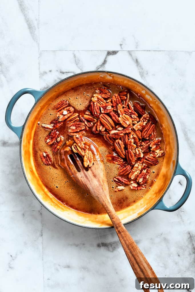 Adding pecans to the rich, caramelly filling. Crunchy pecans being folded into the prepared pecan pie filling mixture.