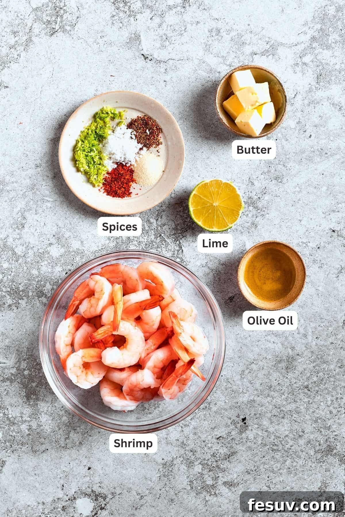 These crispy Shrimp Nachos are piled with layers of flavor from creamy guacamole, juicy shrimp, and spicy, fresh pico de Gallo. The ingredients for the shrimp are shown: shrimp, spices, butter, lime, olive oil.