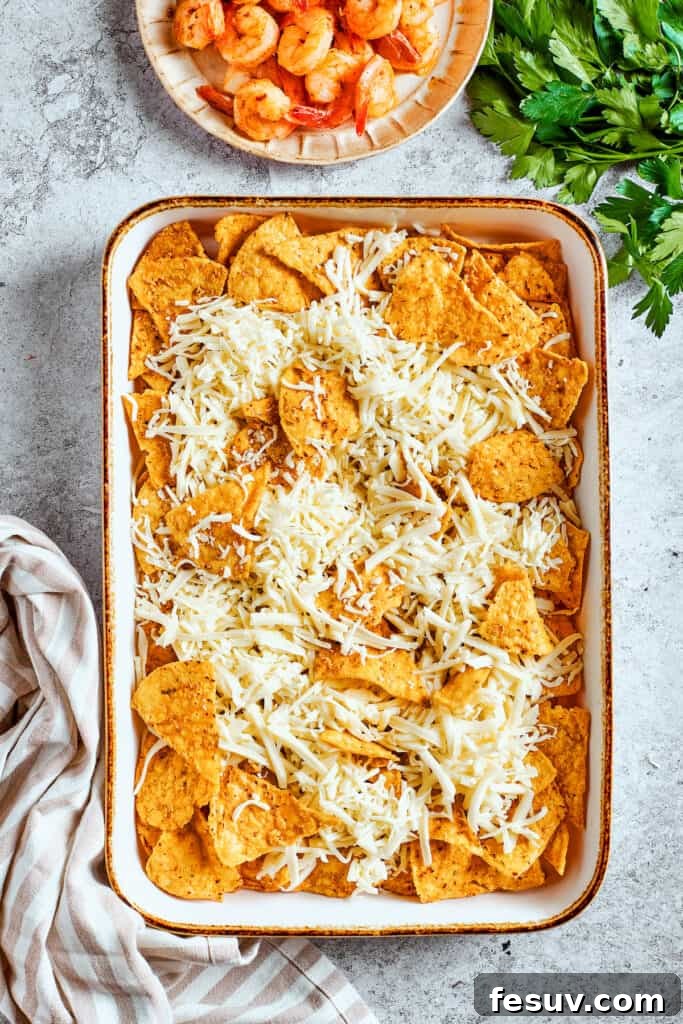 These crispy-crunchy Shrimp Nachos are piled with layers of flavor from creamy guacamole, juicy shrimp, and spicy, fresh pico de Gallo. Shredded cheese is added to the nachos.