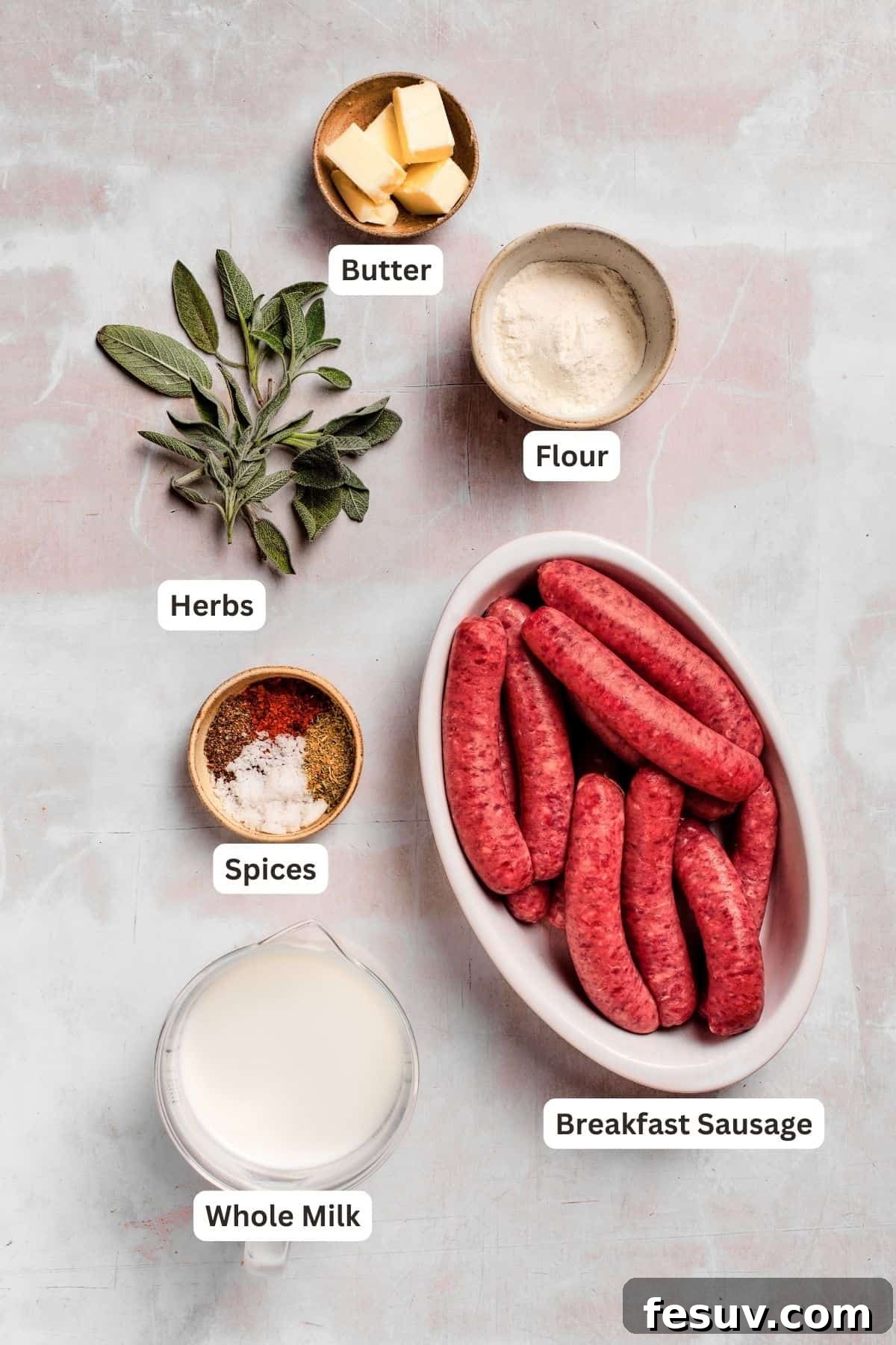 Ingredients laid out for a delicious sausage gravy and biscuits recipe. A vibrant display of fresh ingredients for sausage gravy and biscuits, including ground sausage, a stick of butter, a bowl of all-purpose flour, and various spices and herbs, neatly arranged on a rustic wooden surface.