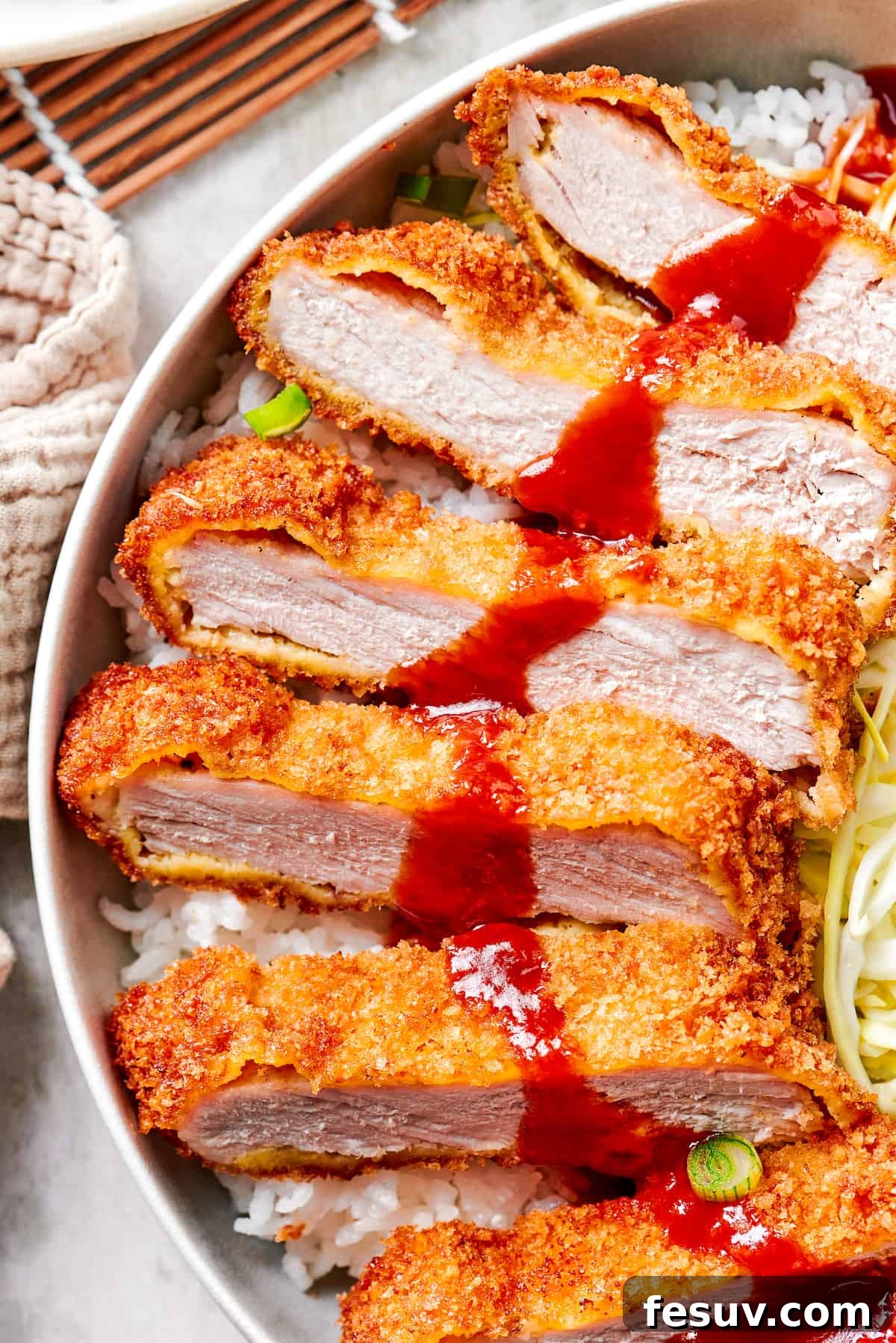 Sliced, crispy Pork Katsu drizzled with homemade Tonkatsu sauce, ready to be served.