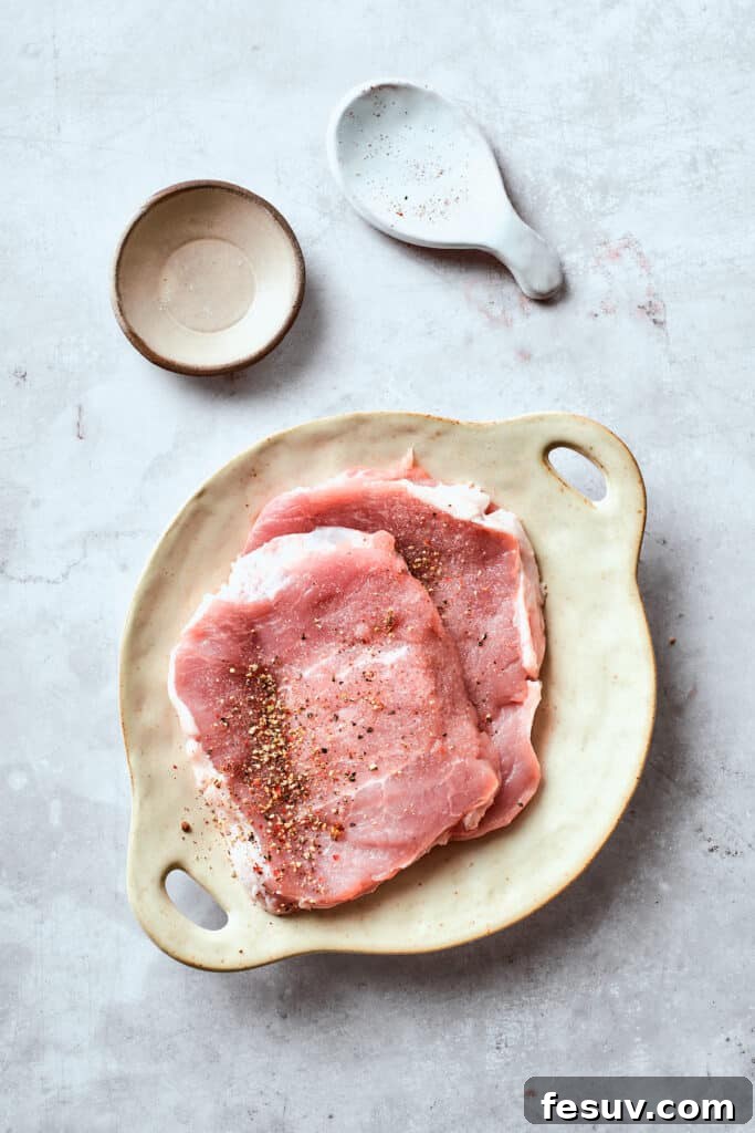 Boneless pork cutlets seasoned with salt and pepper.