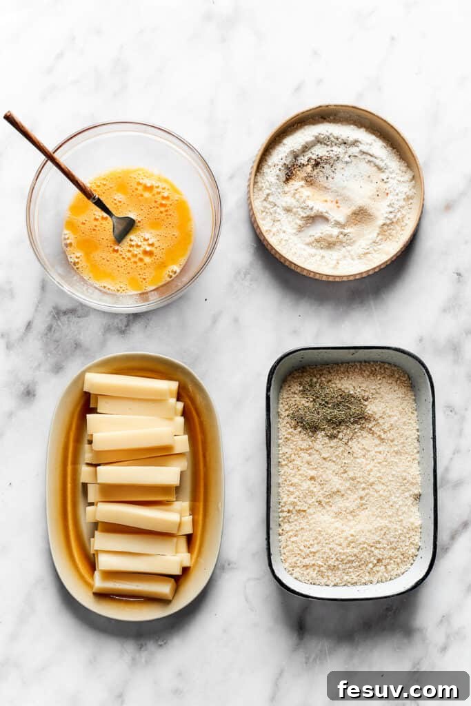 Three shallow dishes set up for breading: one with flour mixture, one with beaten egg, and one with panko breadcrumbs and Italian seasoning.
