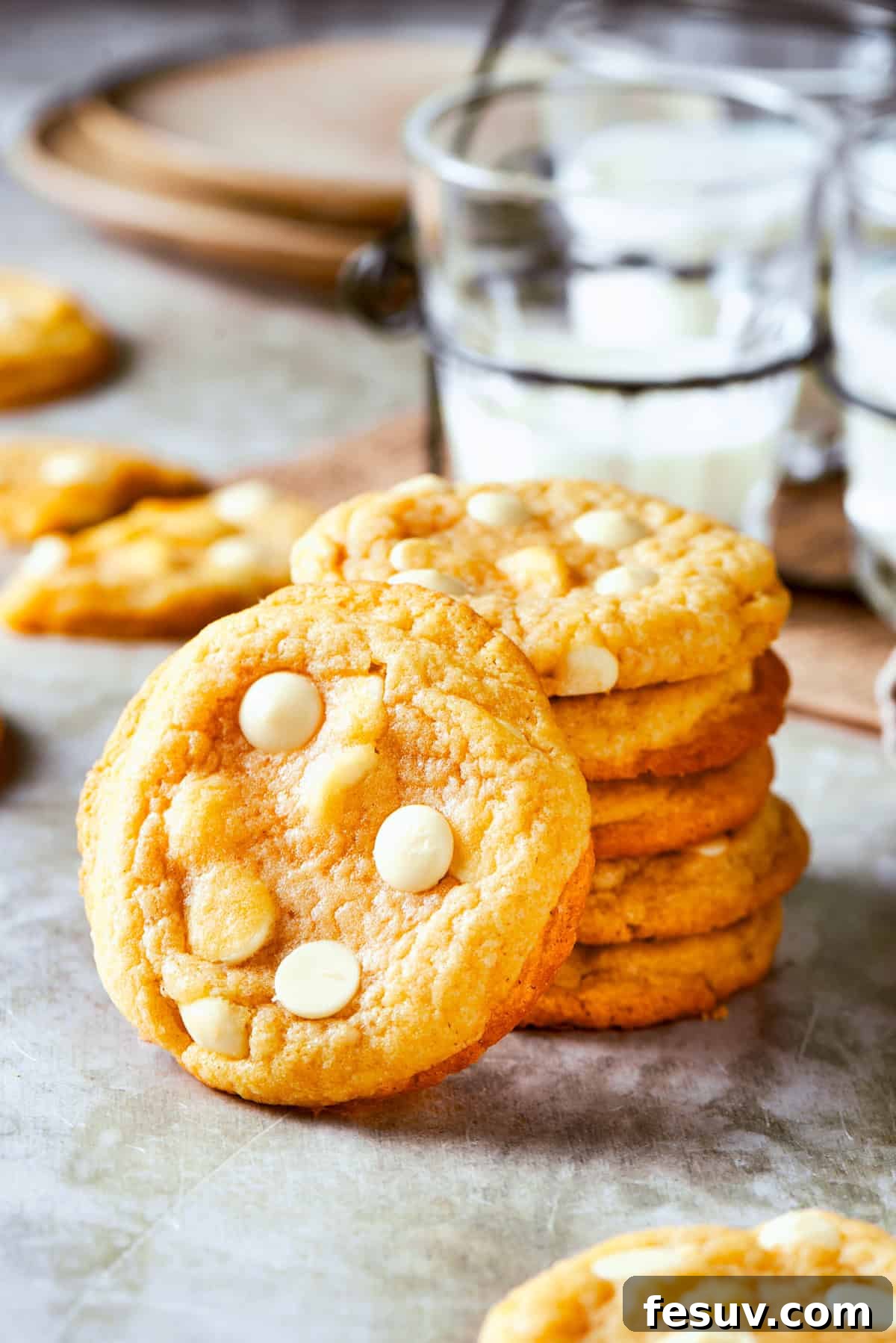 Chewy, buttery White Chocolate Chip Cookies are packed with creamy, sweet white chocolate chips instead of semisweet for an unexpected twist. A tall, enticing stack of golden-brown white chocolate chip cookies with visible melted chips, artfully arranged on a clean white surface, highlighting their perfect texture and delicious appeal.
