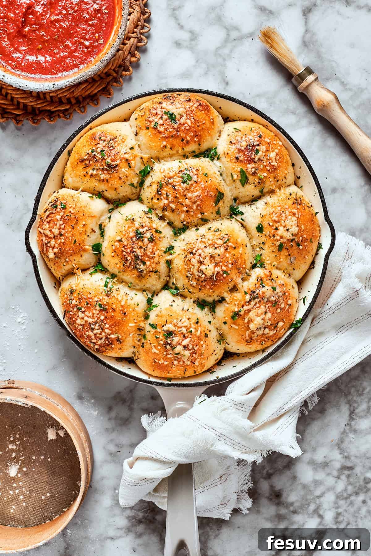 This easy Pizza Bites recipe stuffs spicy pepperoni and gooey mozzarella cheese into little pieces of pizza dough brushed with herb butter. A close-up shot of golden-baked pizza bites, glistening with herb butter and melted cheese.