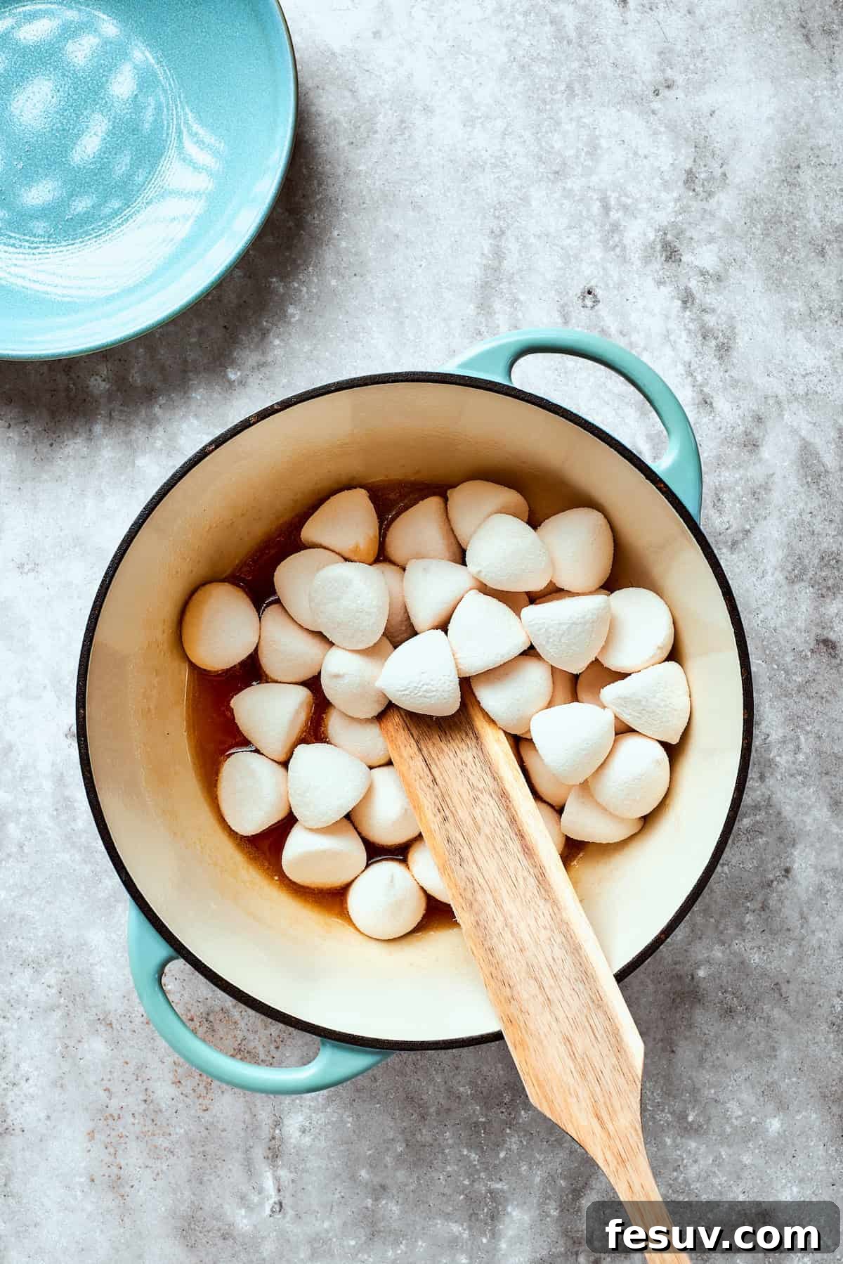 No-bake Peanut Butter Rice Crispy Treats are swirled with creamy peanut butter and capped with a rich layer of melted milk chocolate. Mini marshmallows are stirred into the melted butter and maple syrup mixture in a large saucepan.