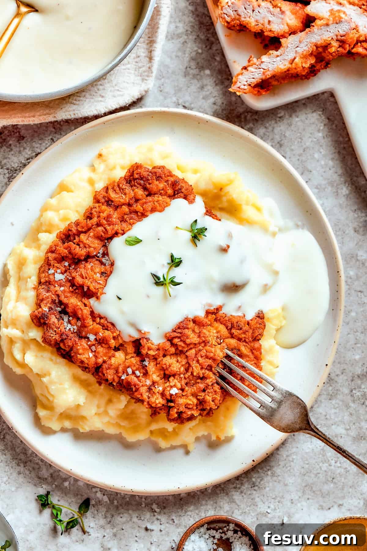 Indulge in this crisp-tender Chicken Fried Steak with irresistible gravy. Crispy chicken fried steak smothered in creamy gravy, served with fluffy mashed potatoes.