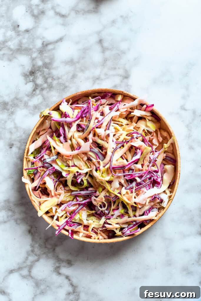 These Chicken Wonton Tacos feature bites of garlicky honey chicken stuffed into crisp wonton shells along with tangy fresh coleslaw. The sauce is combined with the coleslaw mix.