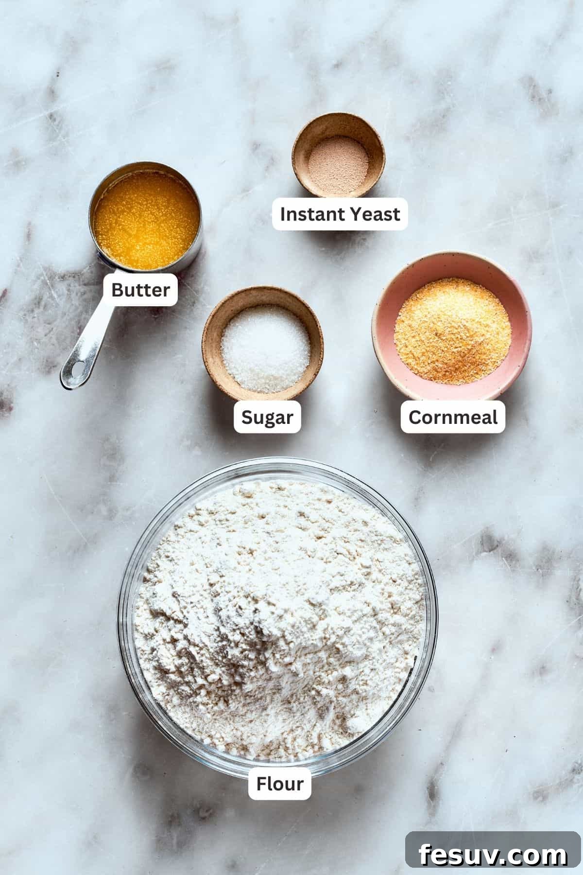 Key ingredients for the signature buttery cornmeal crust of deep dish pizza. Essential ingredients for deep dish pizza crust: all-purpose flour, fine yellow cornmeal, unsalted butter, granulated sugar, and instant yeast.
