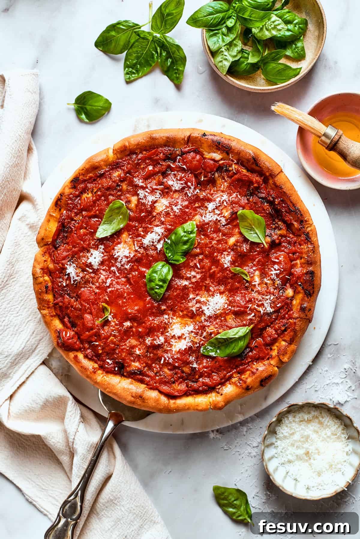 A perfectly baked Deep Dish Pizza, featuring a vibrant tomato sauce and fresh basil. A stunning overhead shot of a freshly baked deep dish pizza, adorned with its rich tomato sauce and garnished with bright green fresh basil leaves, ready to be sliced and served.