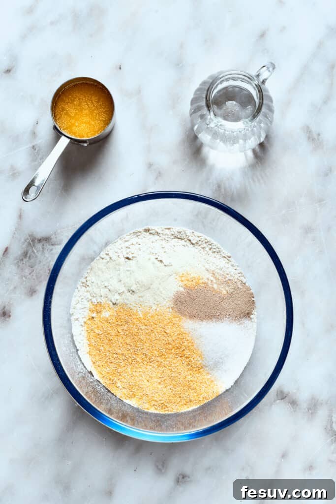 Combine dry ingredients for the deep dish pizza dough. A bowl holds the dry ingredients for the deep dish pizza crust: flour, cornmeal, sugar, instant yeast, and salt, ready to be mixed together.