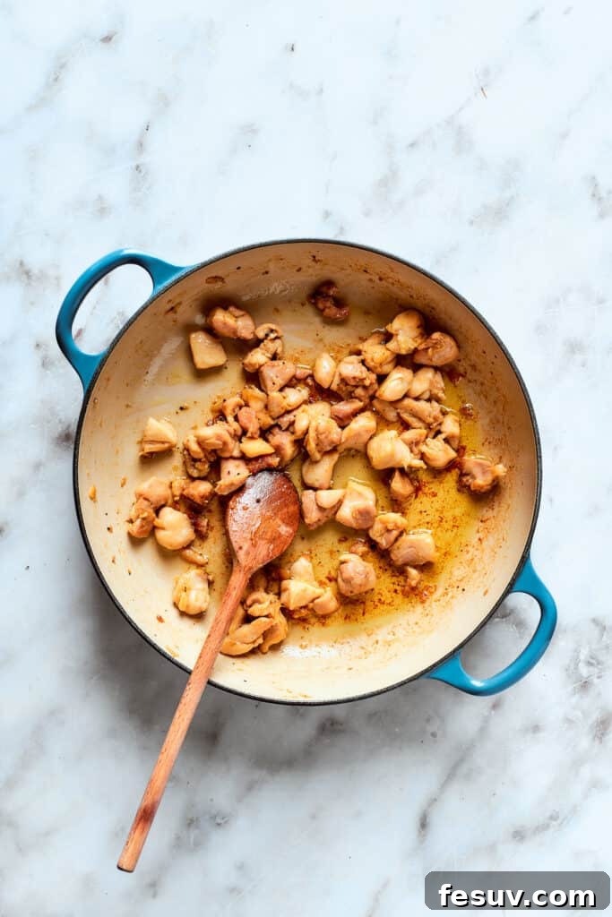 The chicken browns in the pot.