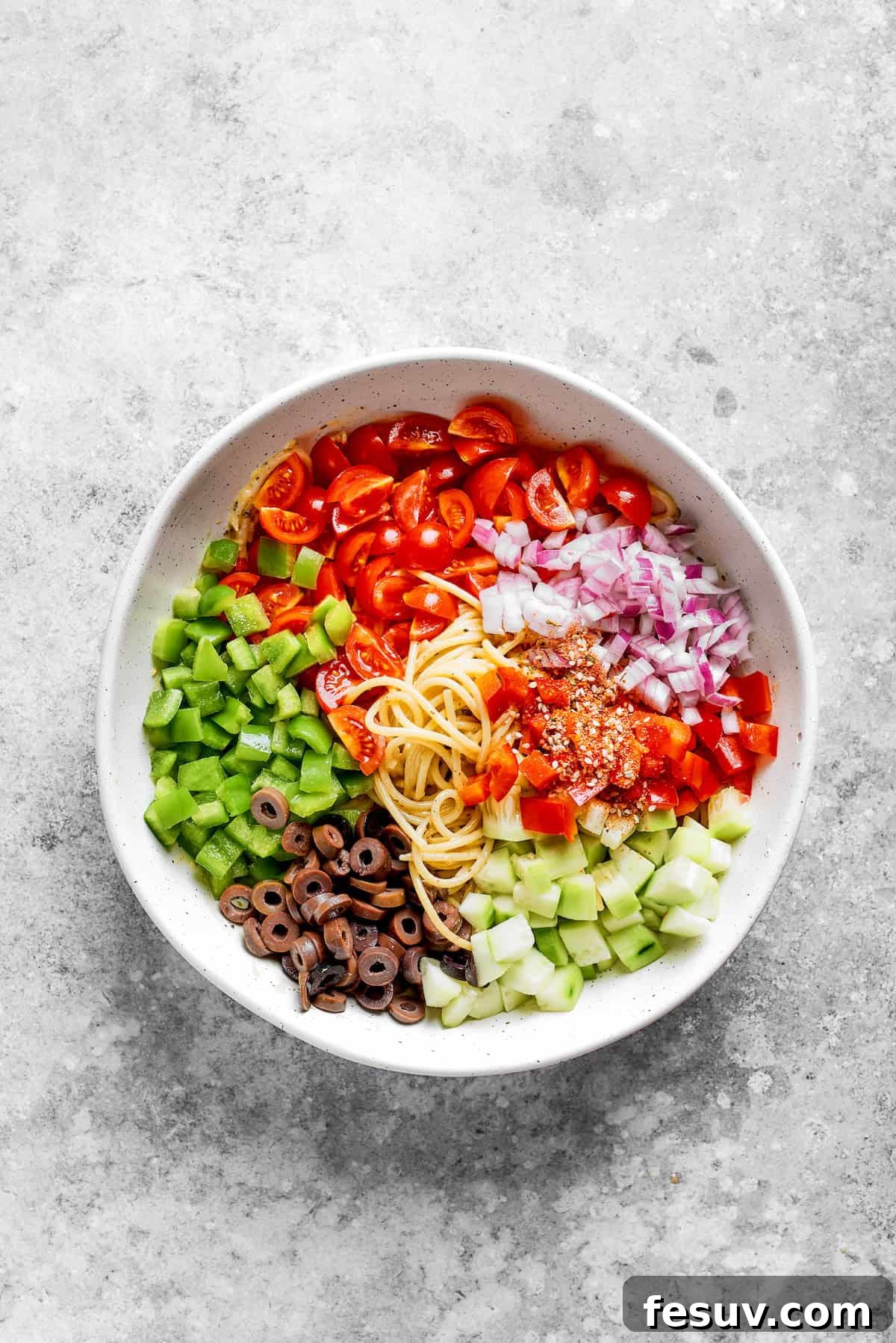 Refreshing Spaghetti Salad is loaded with summery vegetables like juicy cherry tomatoes, crunchy cucumbers, and bell peppers. The vegetables are added to the noodles.