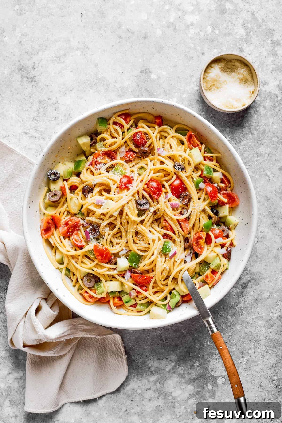 Refreshing Spaghetti Salad is loaded with summery vegetables like juicy cherry tomatoes, crunchy cucumbers, and bell peppers. The vegetables are mixed into the noodles.