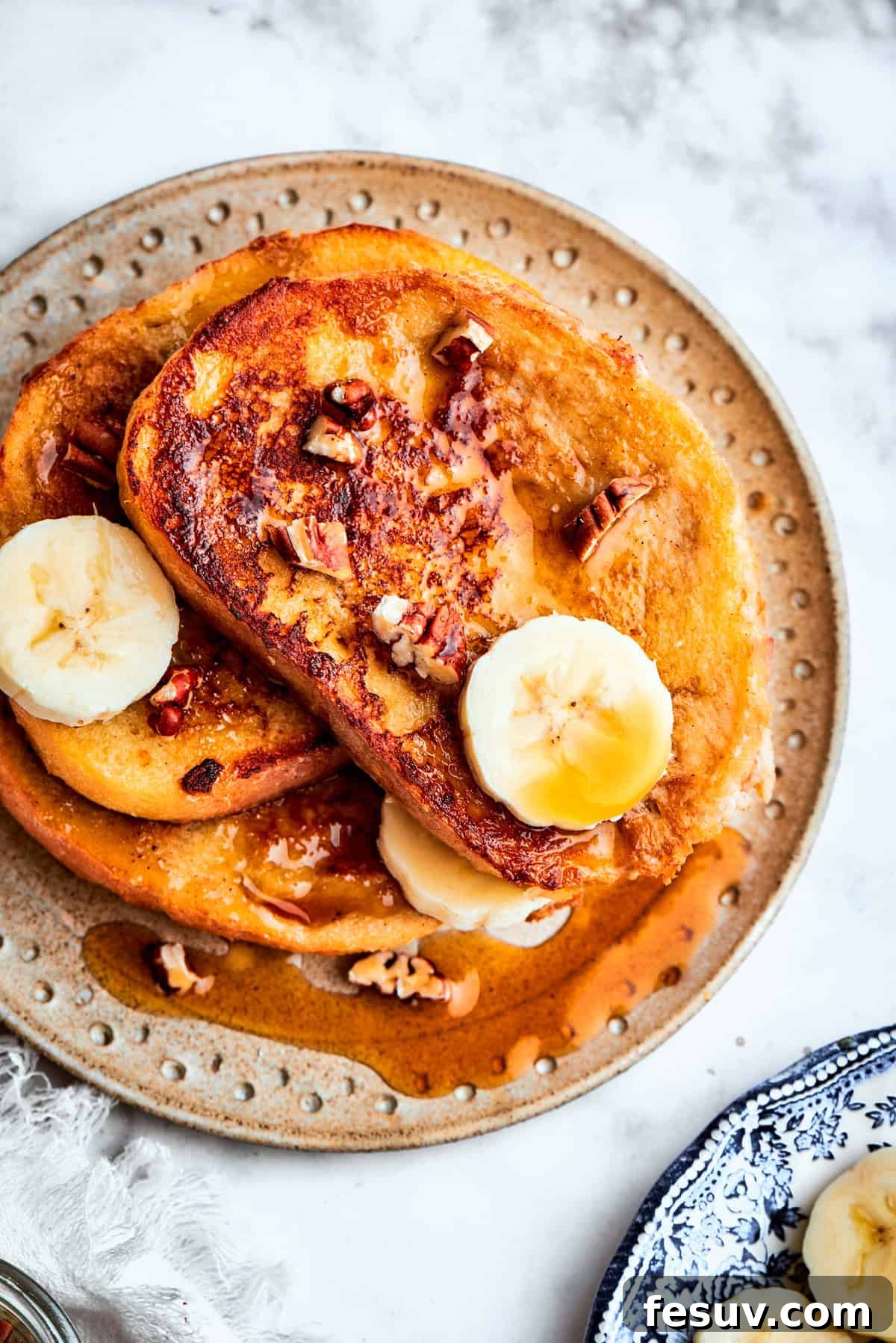 Delicious Banana French Toast served with fresh banana. A beautifully plated stack of golden banana French toast, garnished with fresh banana slices and a delicate dusting of powdered sugar, ready to be enjoyed.