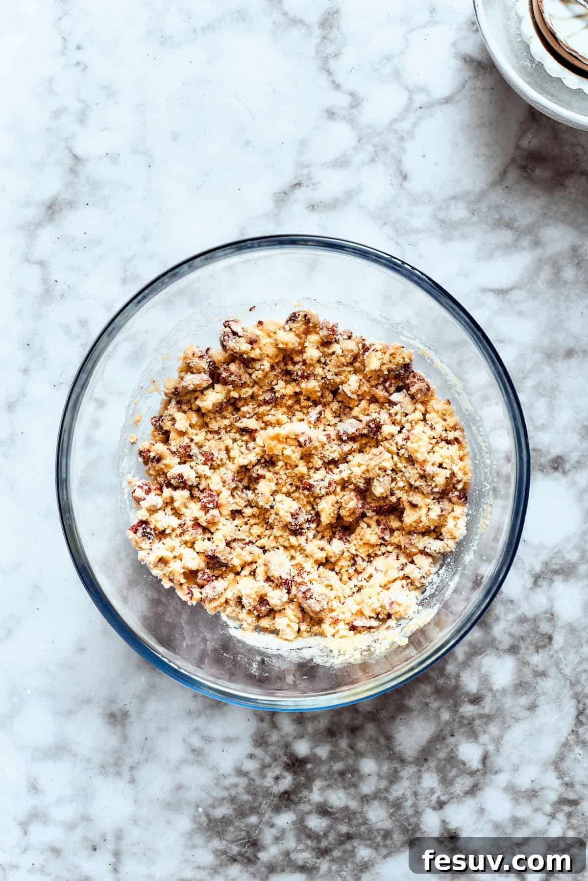 This easy Sex in a Pan recipe layers a tangy-sweet cream cheese filling with vanilla and chocolate puddings on top of a pecan crust. Crust ingredients are added to a glass bowl for mixing.