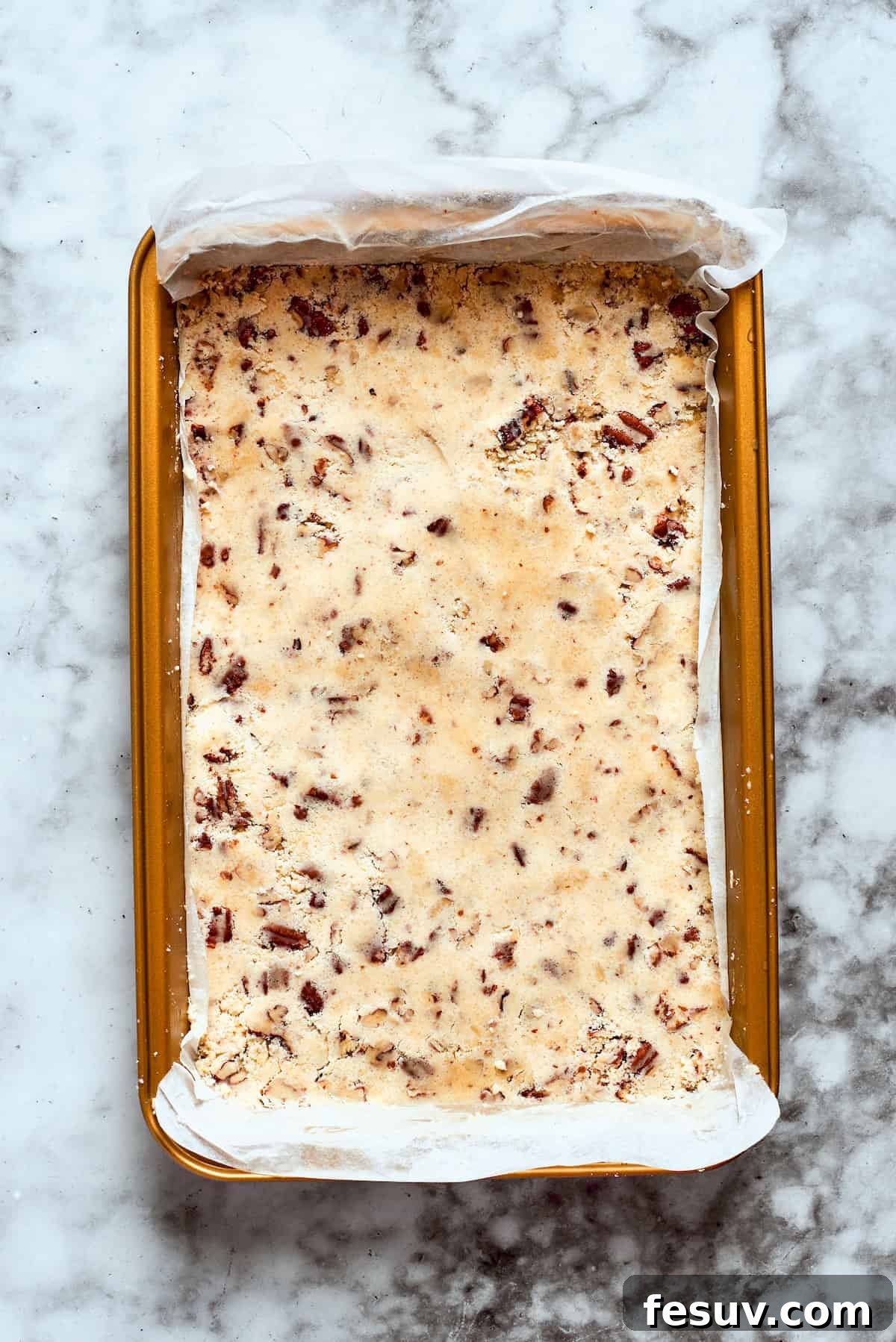 This easy Sex in a Pan recipe layers a tangy-sweet cream cheese filling with vanilla and chocolate puddings on top of a pecan crust. The pecan crust mixture pressed into a baking pan.