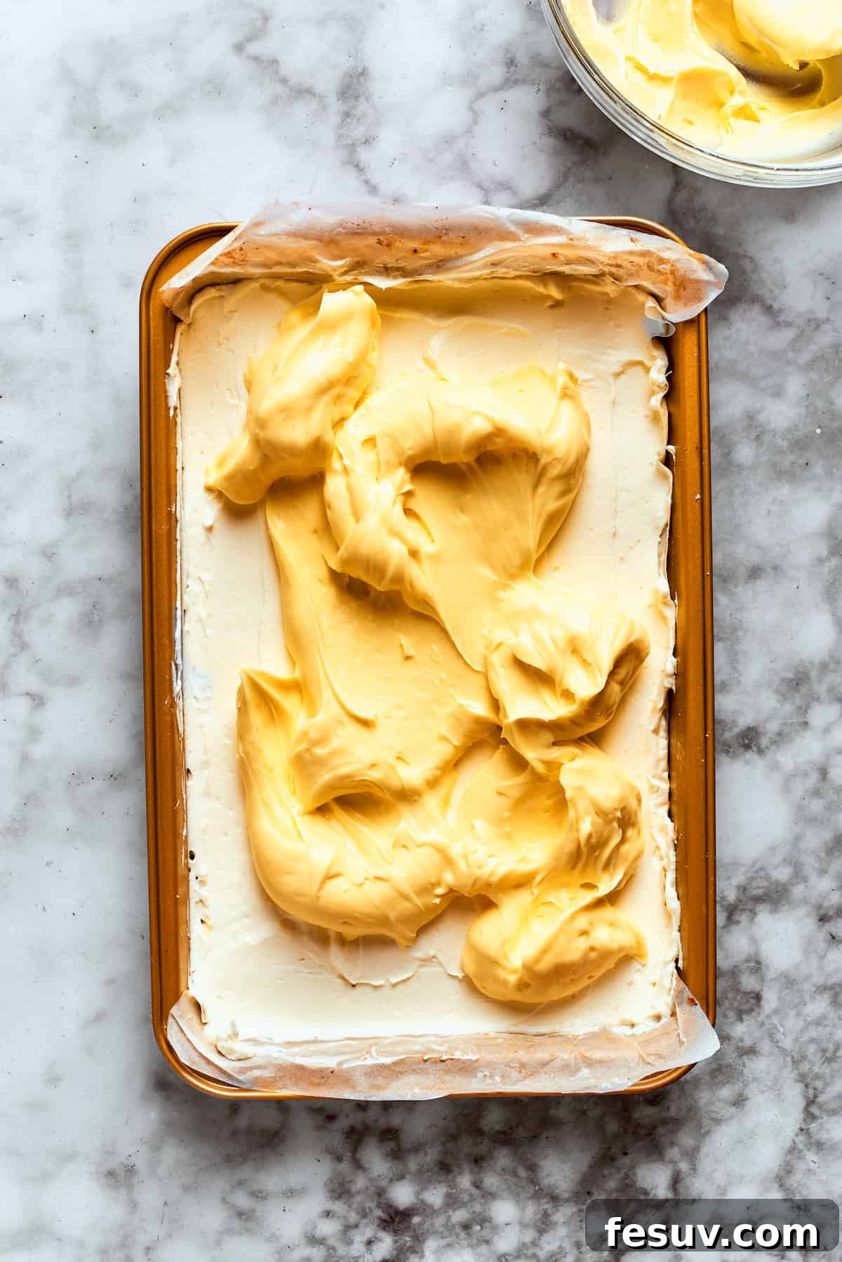 This easy Sex in a Pan recipe layers a tangy-sweet cream cheese filling with vanilla and chocolate puddings on top of a pecan crust. The vanilla pudding layer is spread over the cream cheese layer.