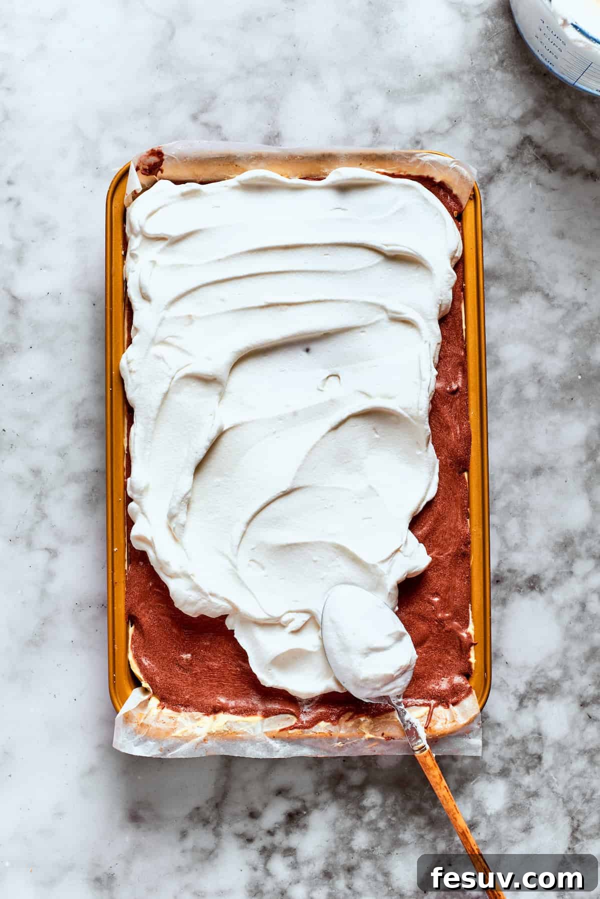 This easy Sex in a Pan recipe layers a tangy-sweet cream cheese filling with vanilla and chocolate puddings on top of a pecan crust. Cool Whip is spread over the top of the dessert, creating a smooth finish.