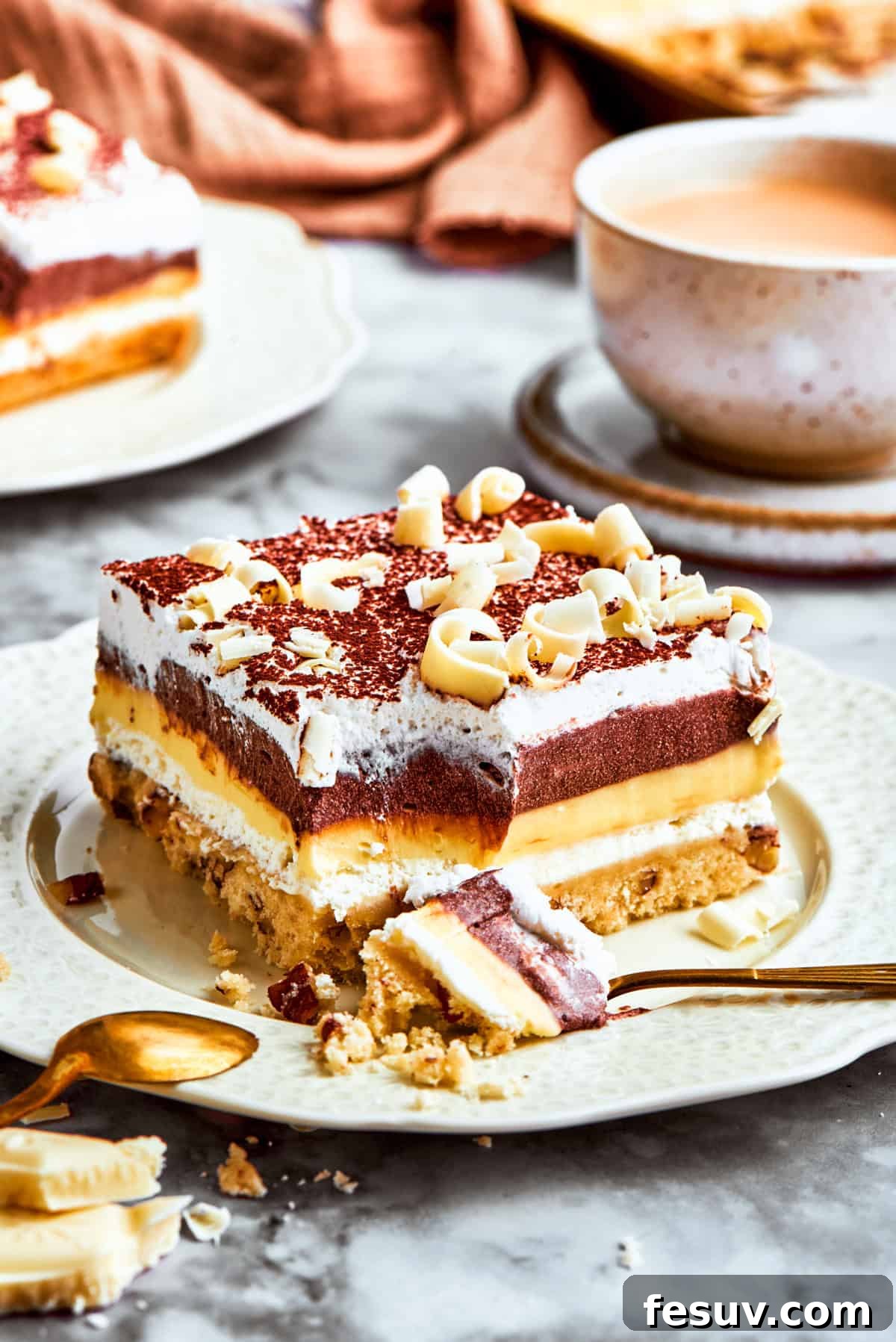 This easy Sex in a Pan recipe layers a tangy-sweet cream cheese filling with vanilla and chocolate puddings on top of a pecan crust. A layered chocolate and vanilla no-bake dessert called sex in a pan served on a plate, ready to be enjoyed.