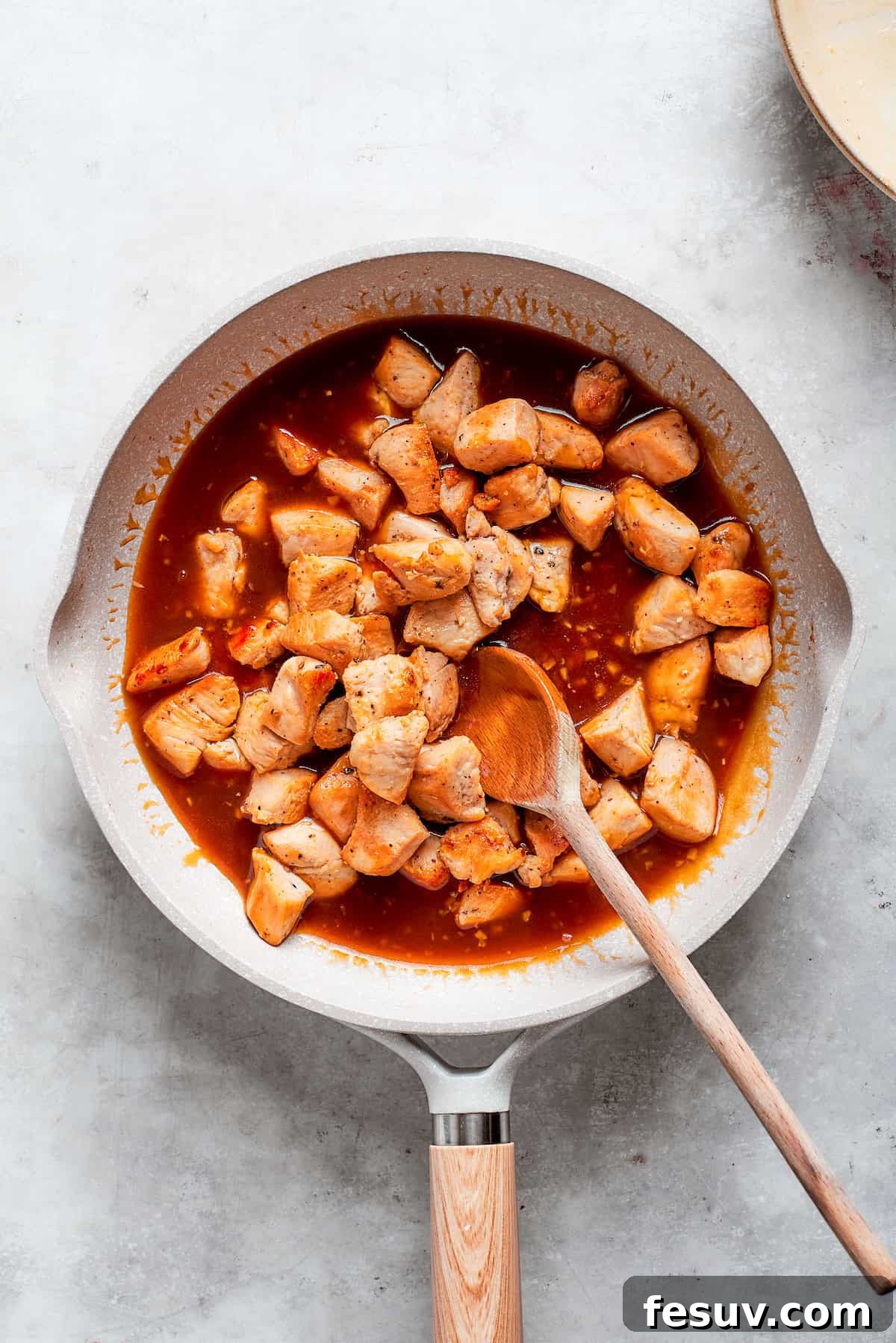 The chicken is added back to the pan of sauce.