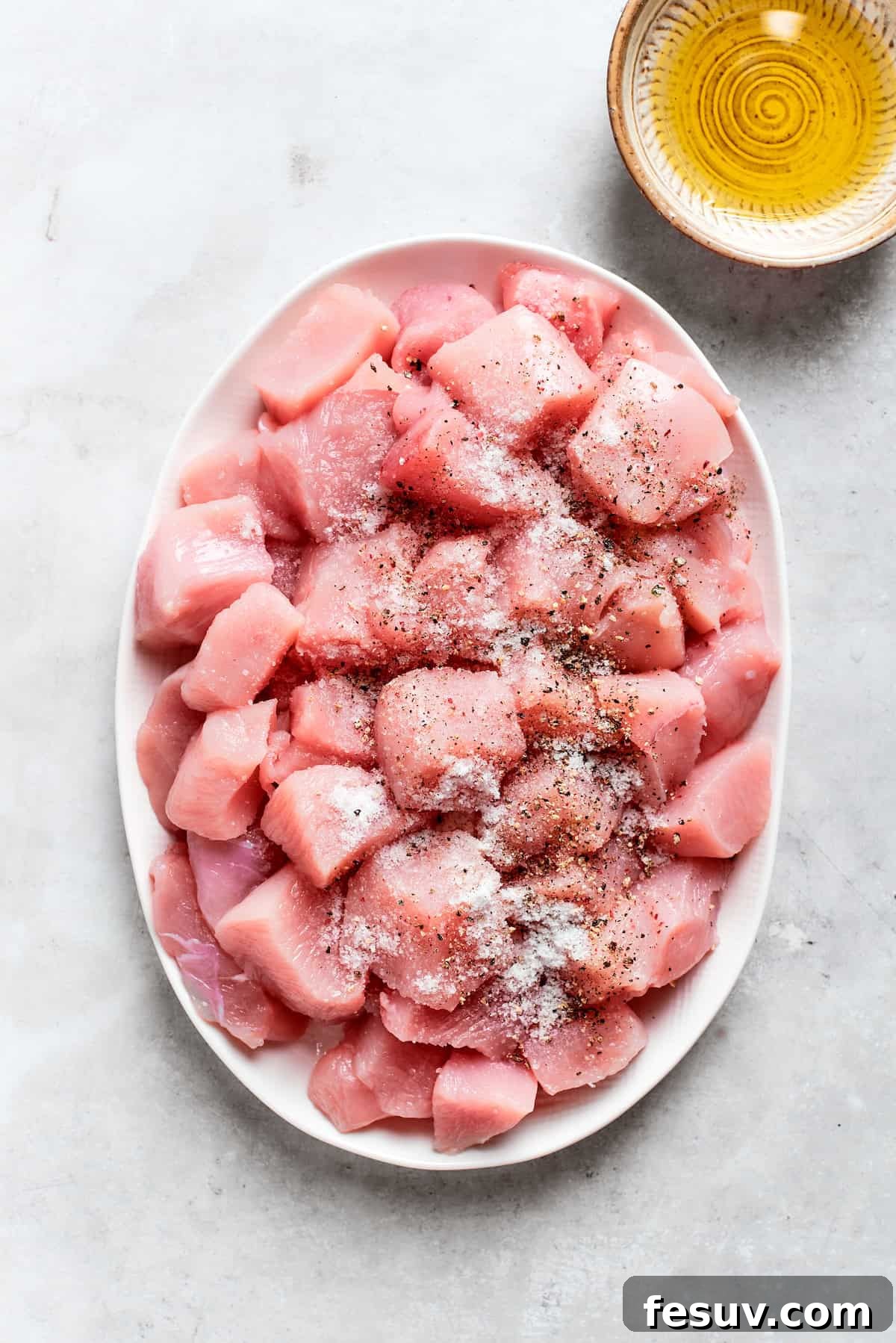 Chicken pieces are seasoned with salt and pepper.